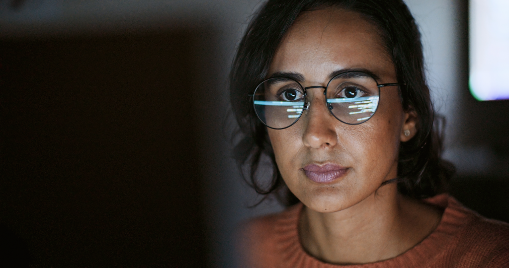 A female member of staff is working on a computer, staring intently at it.