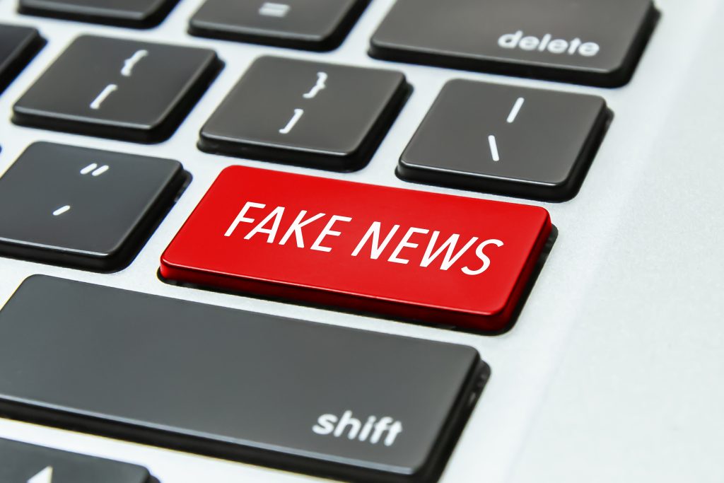 A keyboard displaying a red button titled 'Fake news'